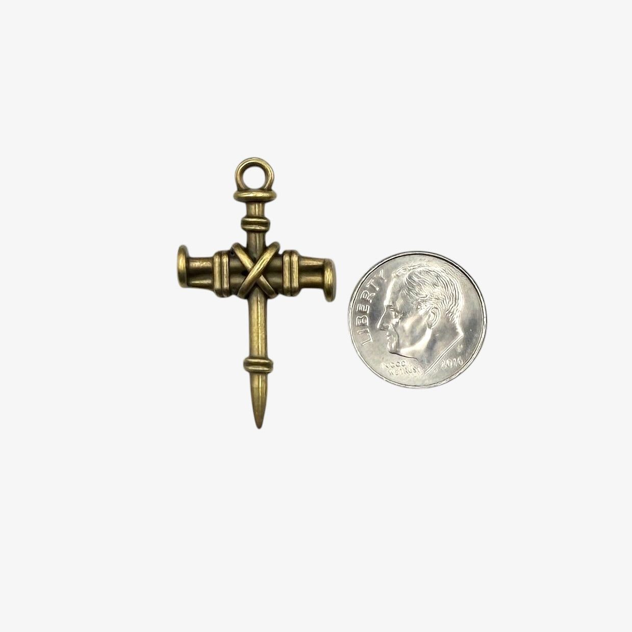Small brass cross charm on a white background