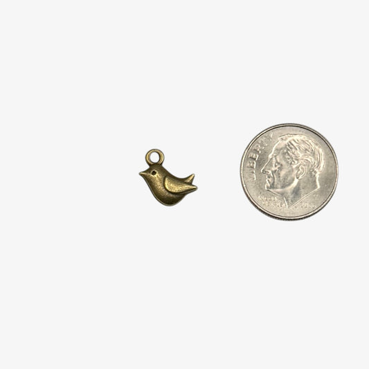 Small gold bird charm next to a U.S. quarter for size comparison on a white background