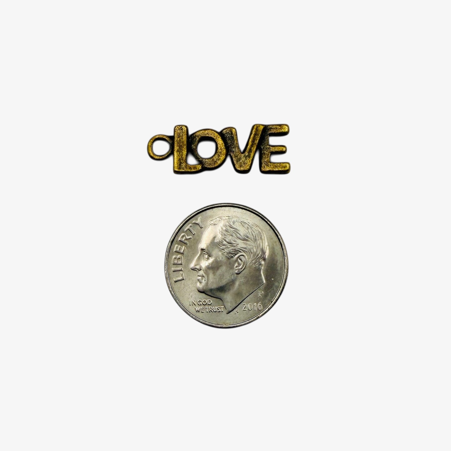 Small coin with bronze 'LOVE' charm on a white background.