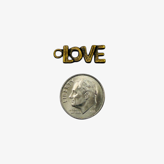Small coin with bronze 'LOVE' charm on a white background.