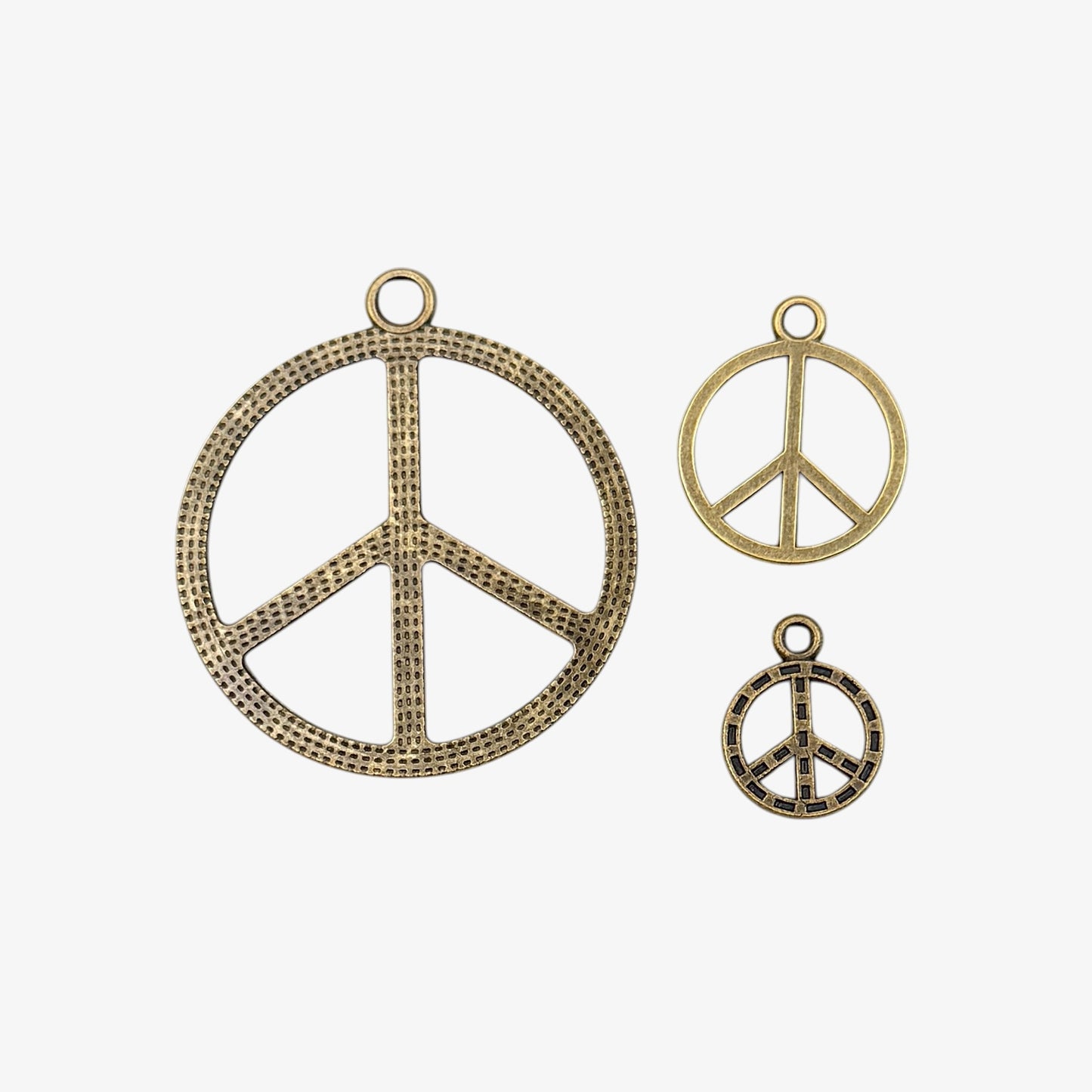 Three peace symbol pendants on a white background