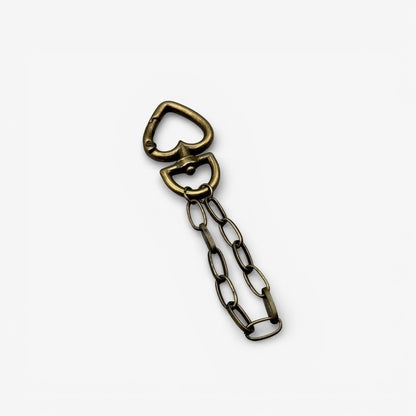 Bronze bottle opener with chain on a white background