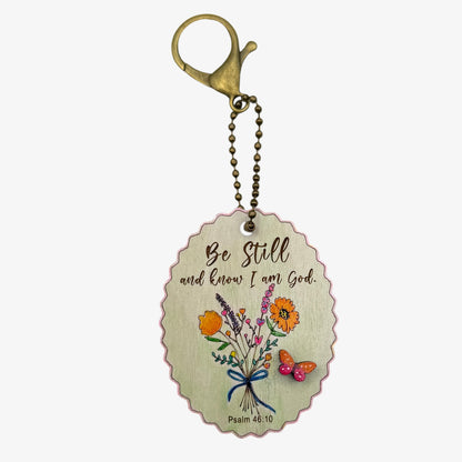 Keychain with floral design and motivational quote on a white background