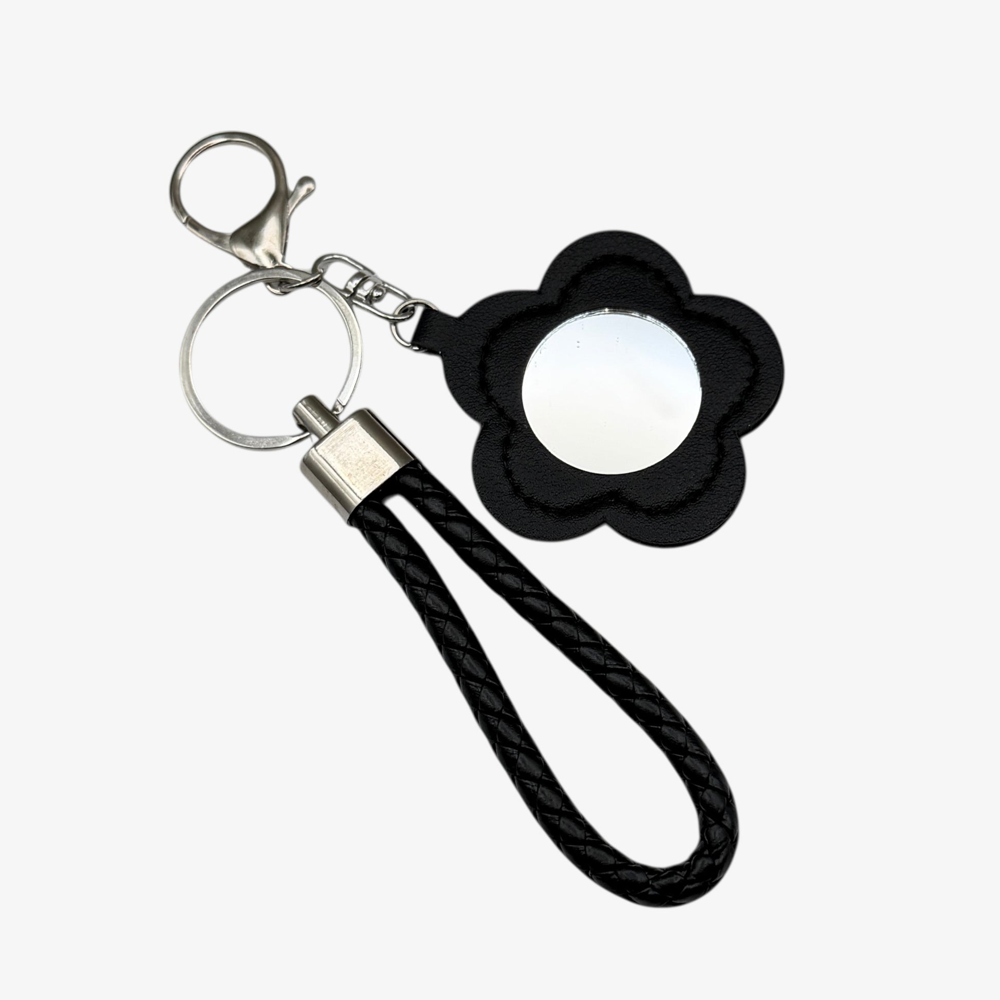 Keychain with black flower-shaped phone holder and black rope strap on a white background