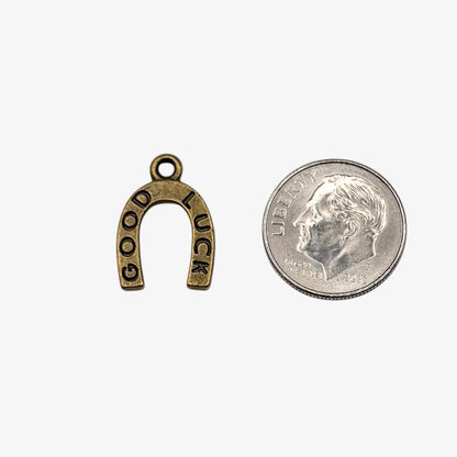 Small gold 'Good Luck' charm on a white background
