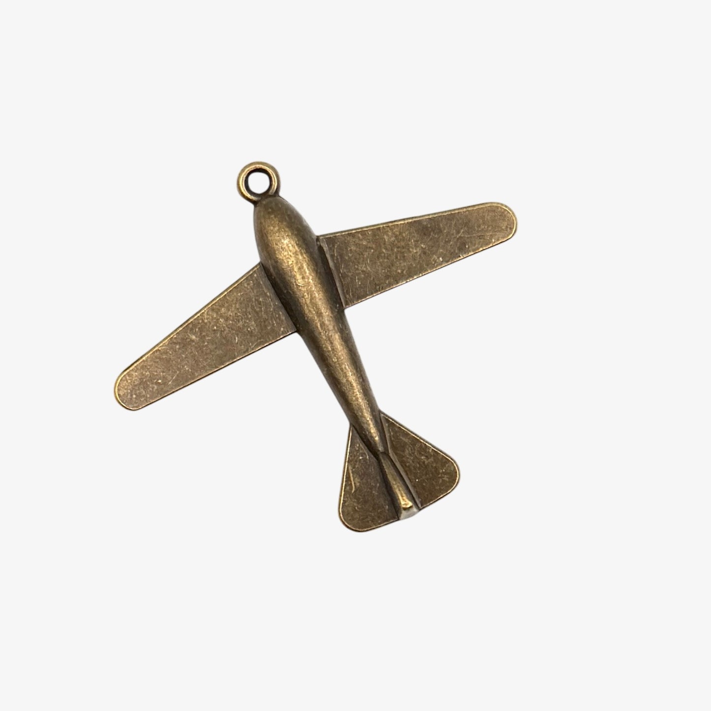 Bronze airplane-shaped pendant on a white background