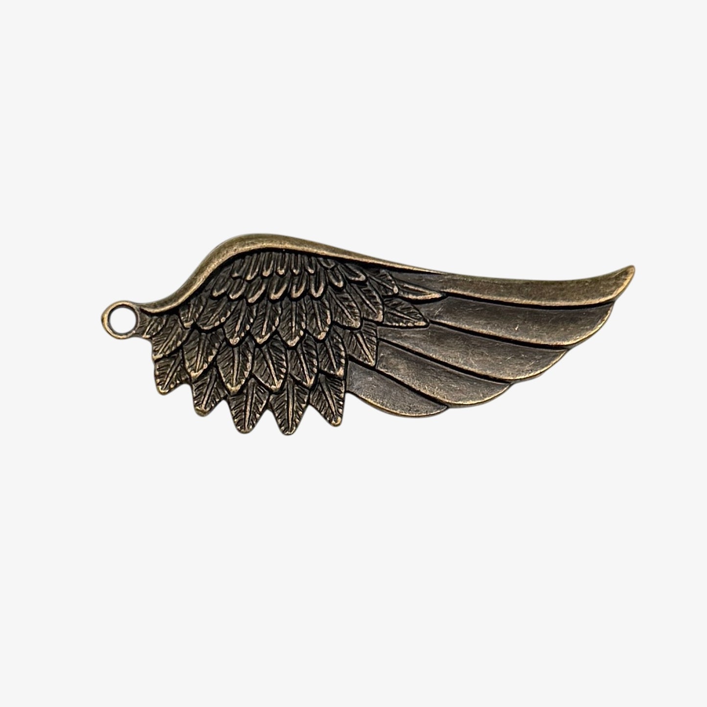 Bronze wing-shaped pendant on a white background
