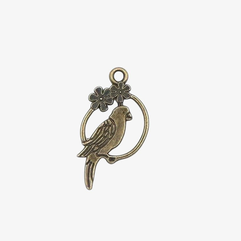 Bronze-colored parrot pendant with floral elements on a white background