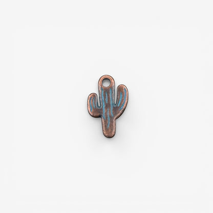 Cactus-shaped copper charm with blue engraving on a white background