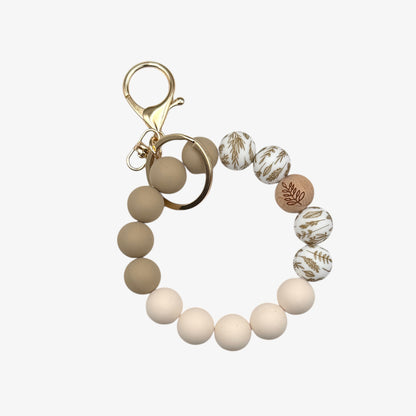 Beaded keychain with beige and white beads on a white background