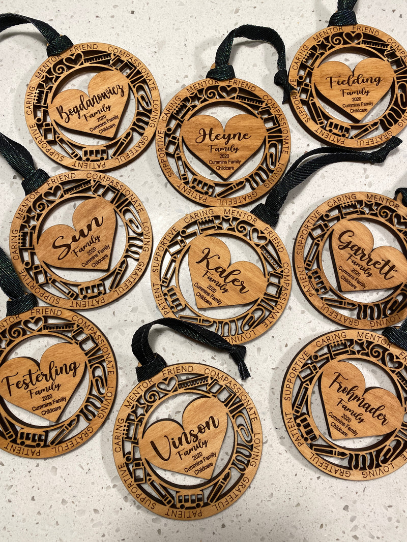 Wooden heart-shaped ornaments with engraved text on a textured surface
