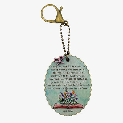 Decorative keychain with a quote and floral design on a white background