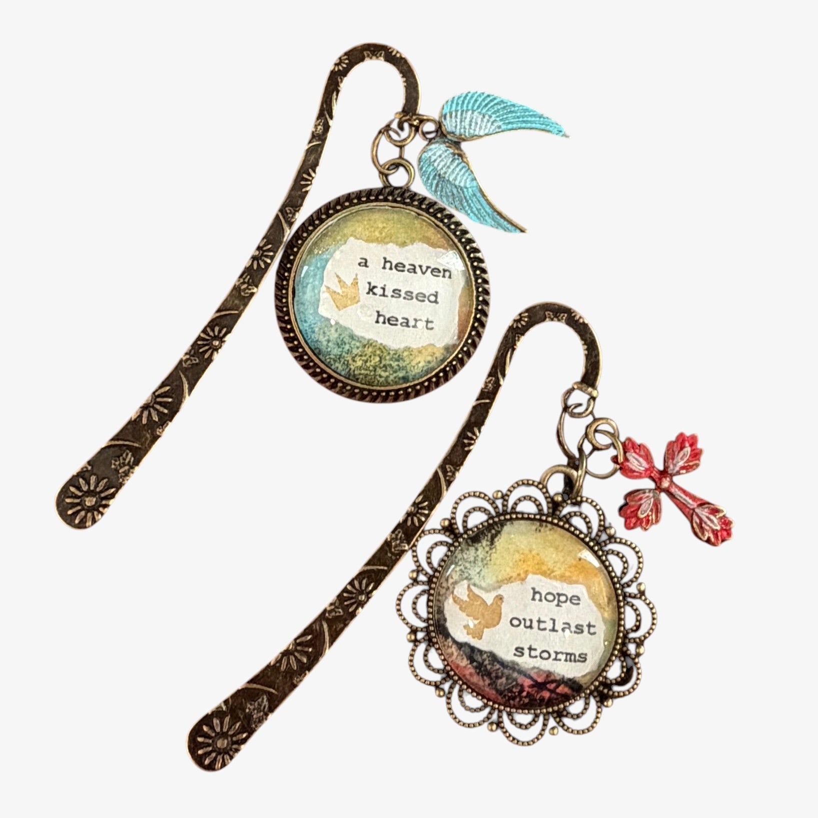 Two decorative bookmarks with inspirational quotes and charms on a white background