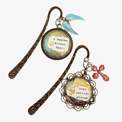 Two decorative bookmarks with inspirational quotes and charms on a white background