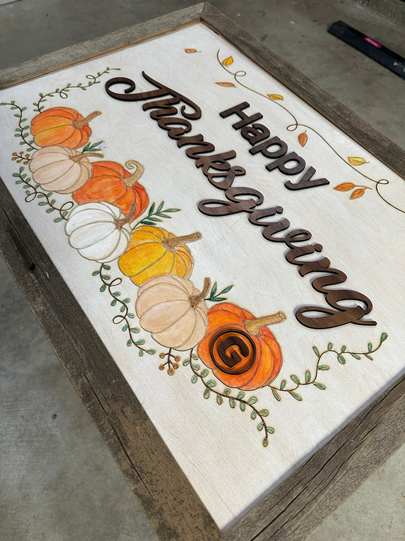 Decorative sign with 'Happy Thanksgiving' text and pumpkins on a wooden frame.