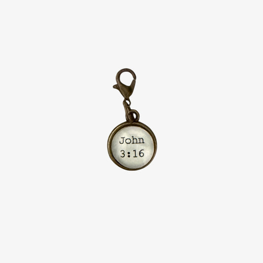 Round metal charm with 'John 3:16' text on a white background