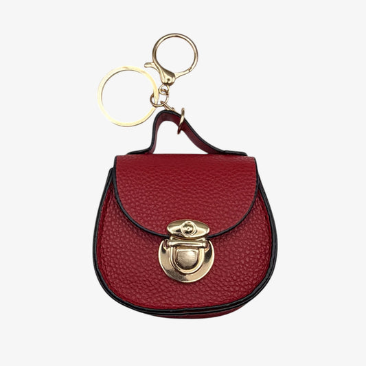 Red leather keychain purse with gold accents on a white background