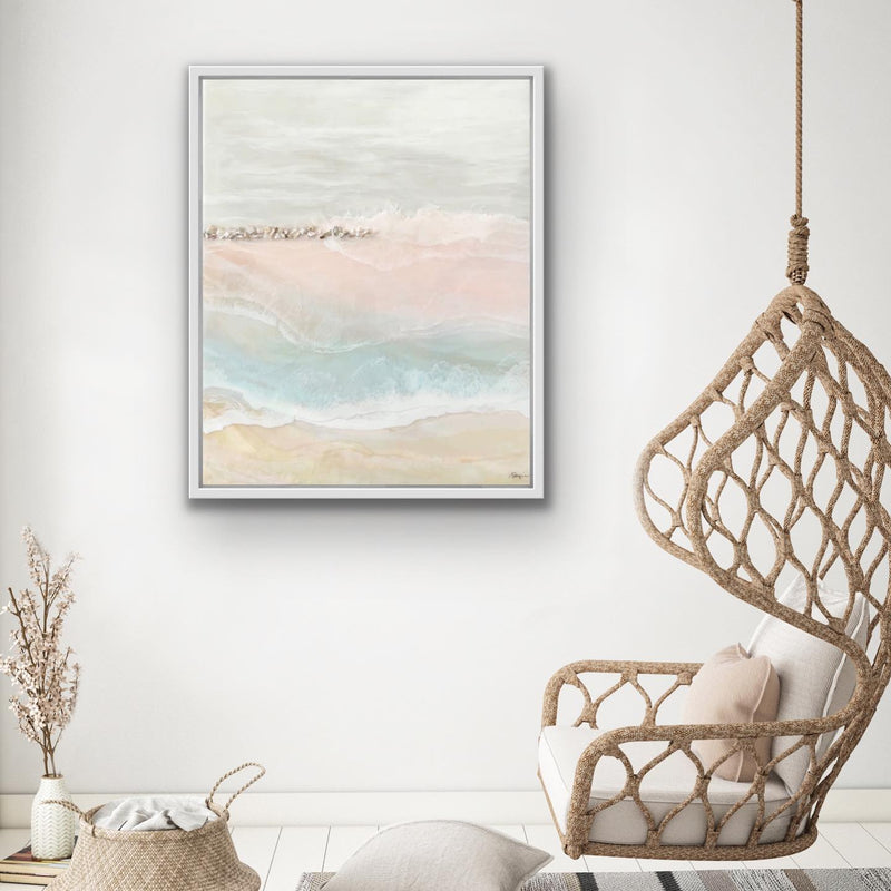 Suspended chair with a pillow next to a framed abstract artwork on a white wall.