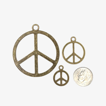 Three peace symbol pendants of different sizes 
