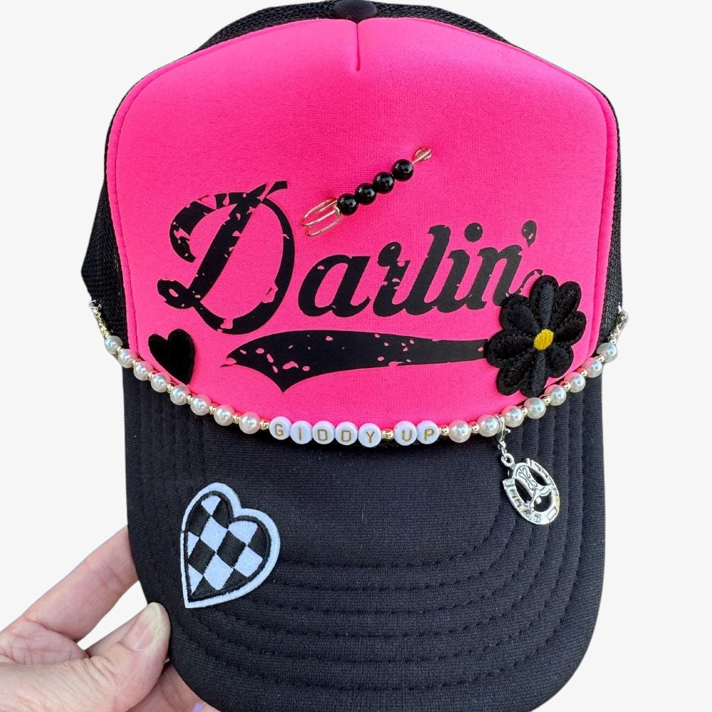 Hot pink and black custom trucker hat with patches and chain