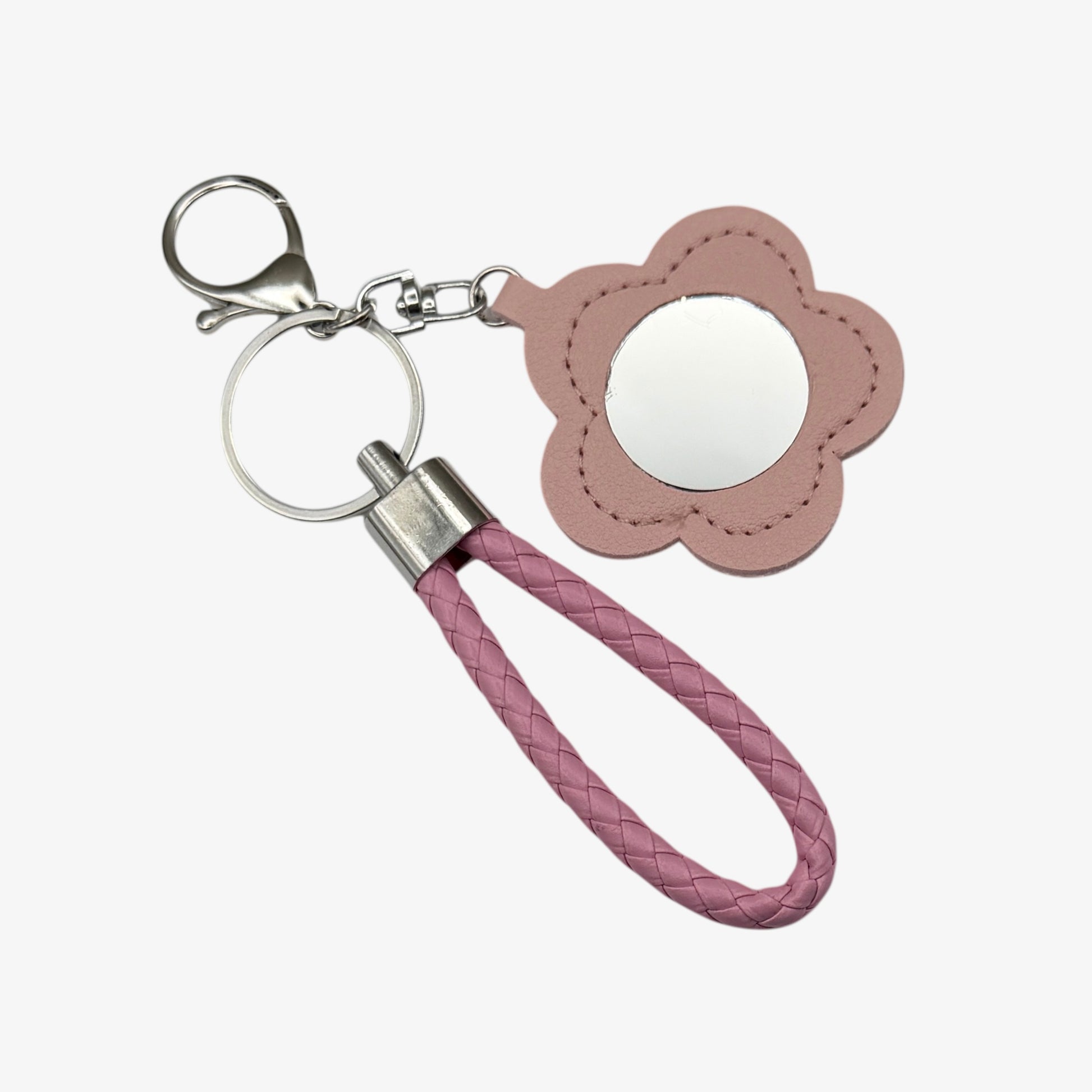 Pink flower-shaped keychain with a mirror and braided handle on a white background