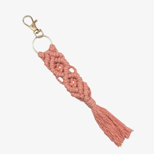 Pink macrame keychain with a tassel on a white background