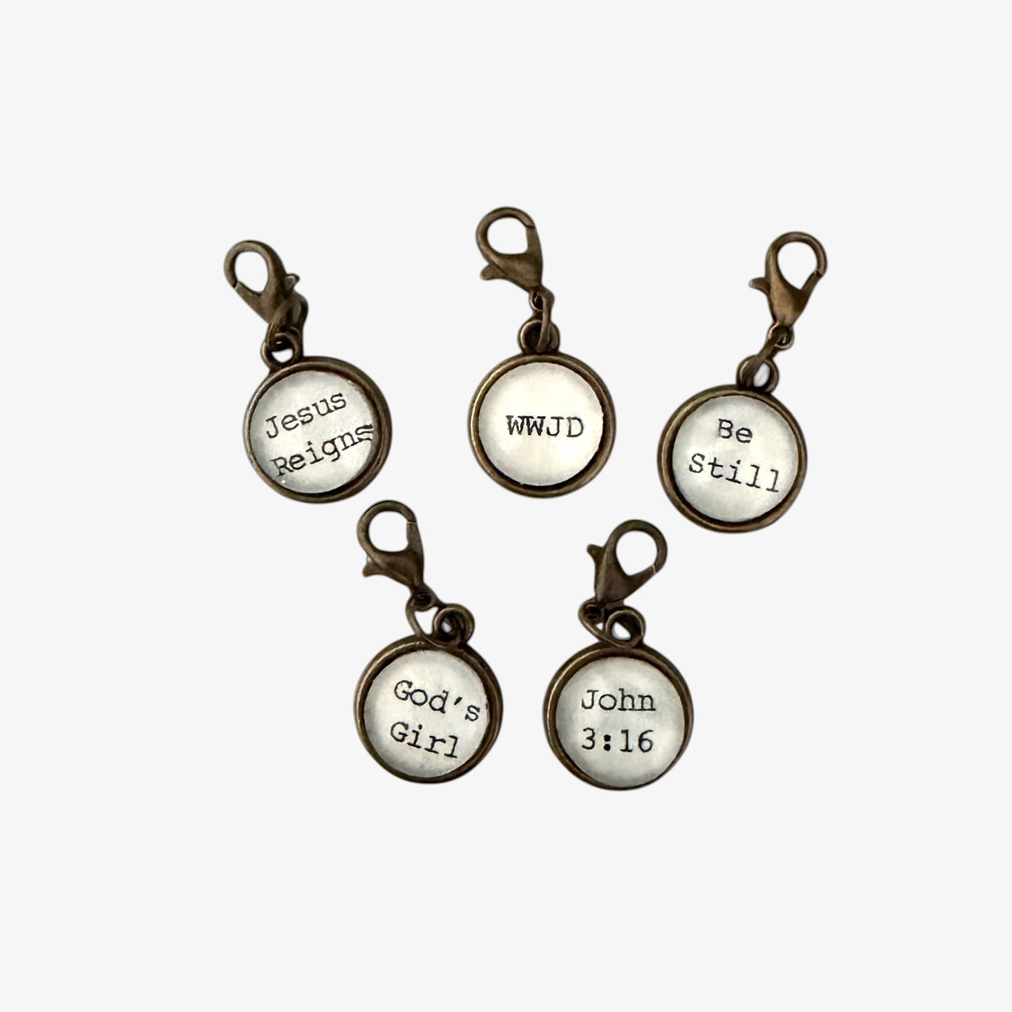 Set of five motivational keychains with religious sayings on a white background