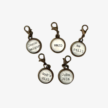 Set of five motivational keychains with religious sayings on a white background