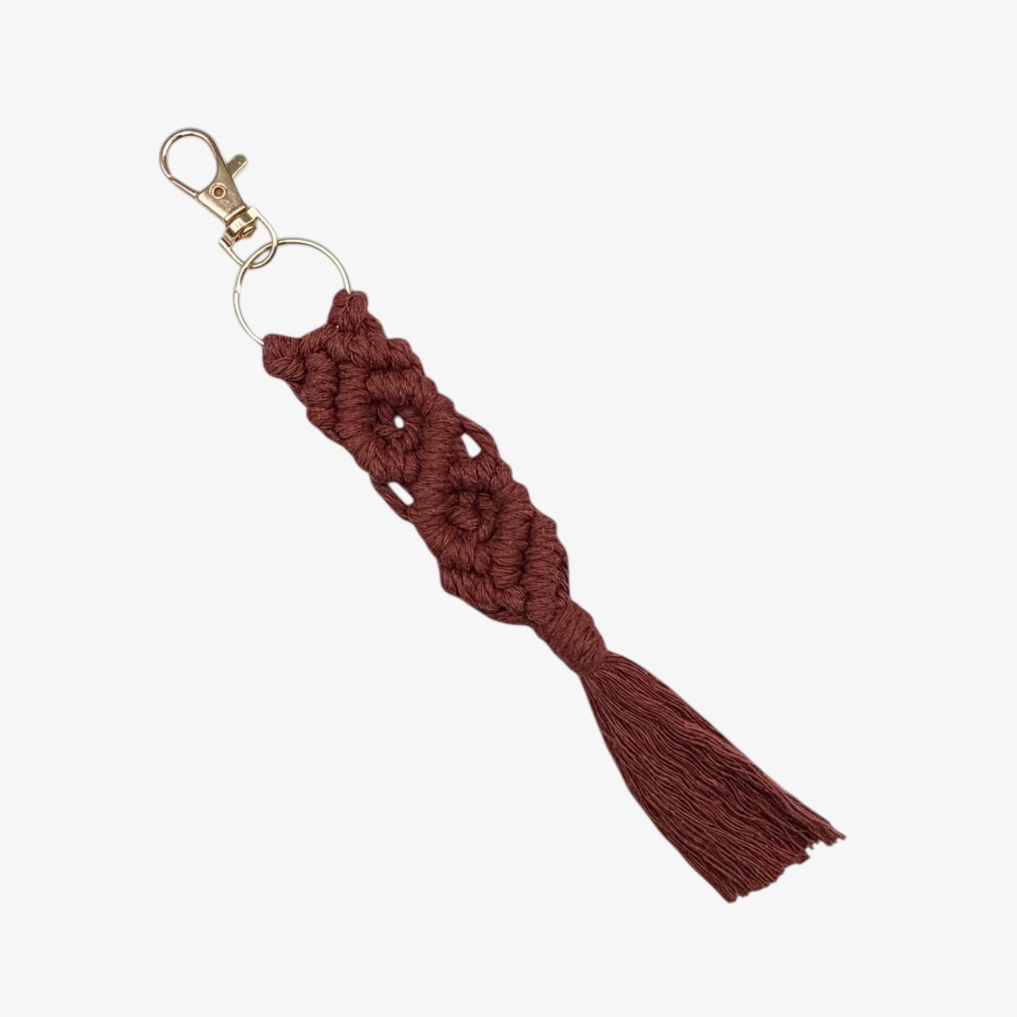 Terracotta macrame keychain with a gold clasp on a white background
