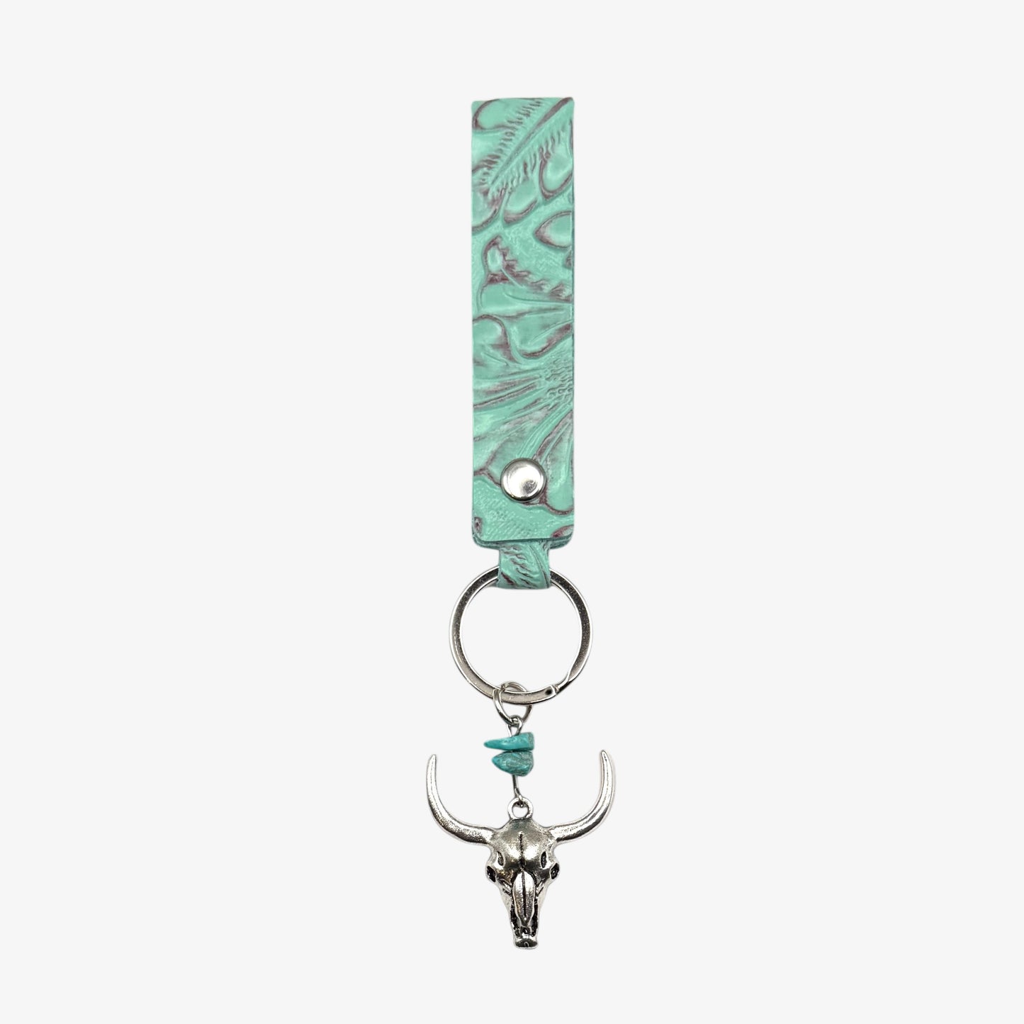 Turquoise leather keychain with bull skull charm on a white background