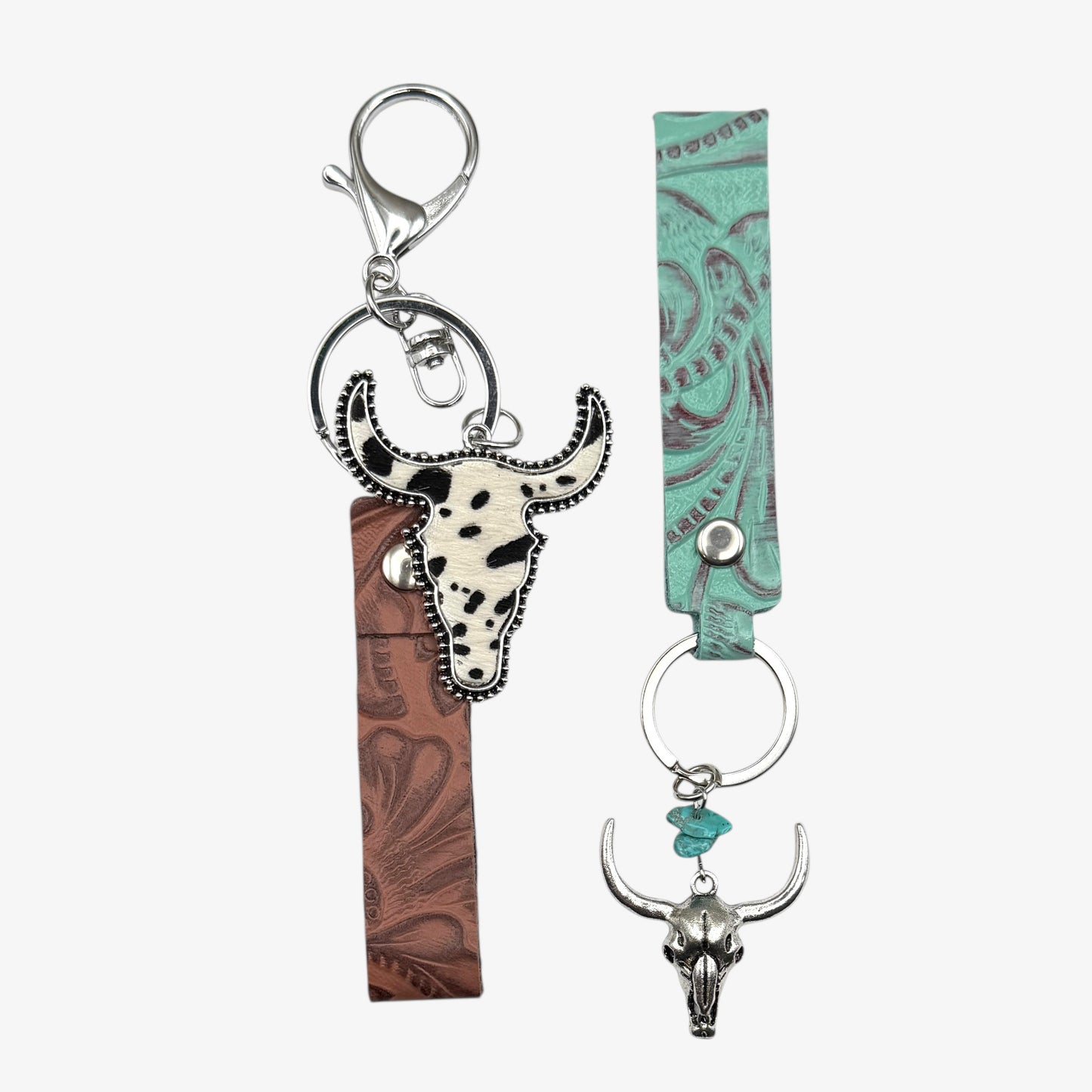 Two keychains with bull head designs on a white background