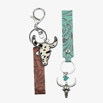 Two keychains with bull head designs on a white background
