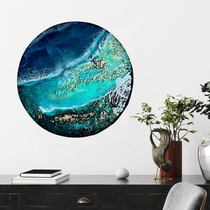Round abstract artwork with blue and green colors on a wall above a desk.