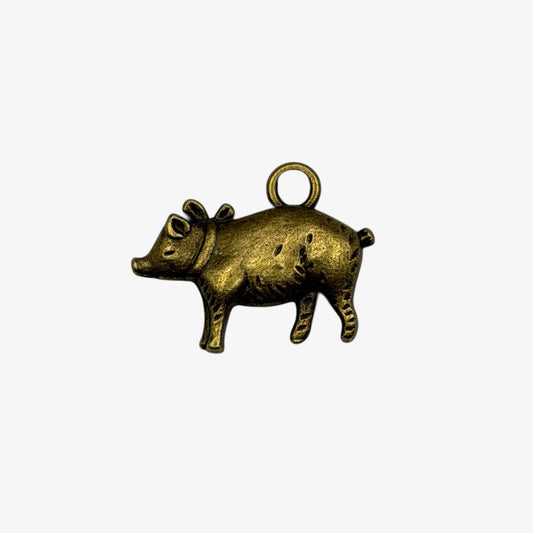 Bronze pig charm on a white background
