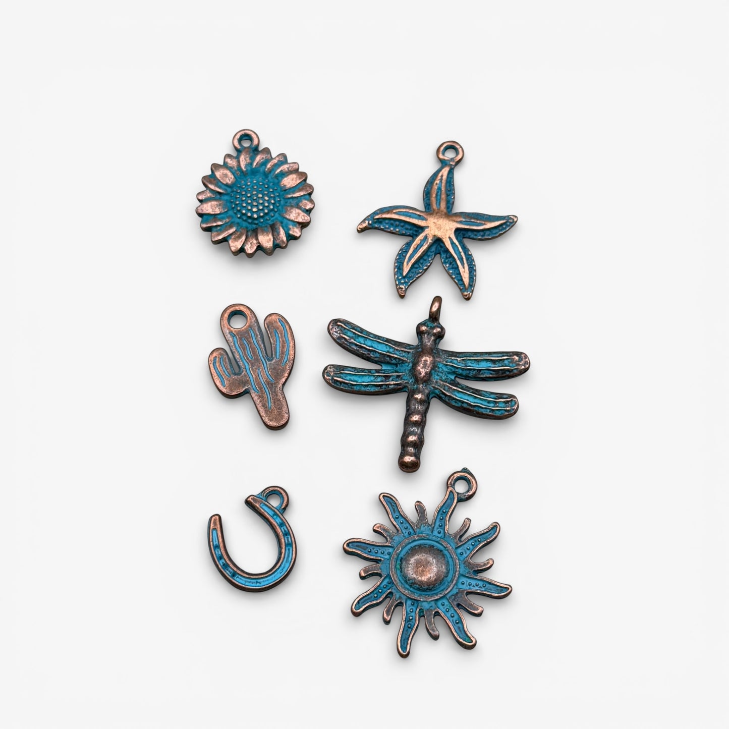 Set of copper and blue enamel charms on a white background