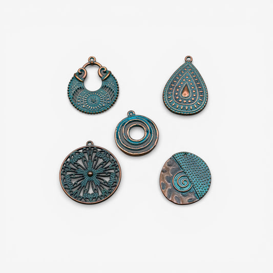 Set of five decorative metal pendants on a white background