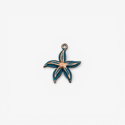 Starfish-shaped pendant with copper and blue enamel on a white background