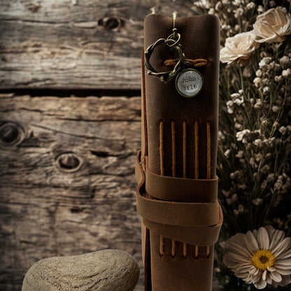 Brown leather quiver with archery accessories on a rustic wooden background