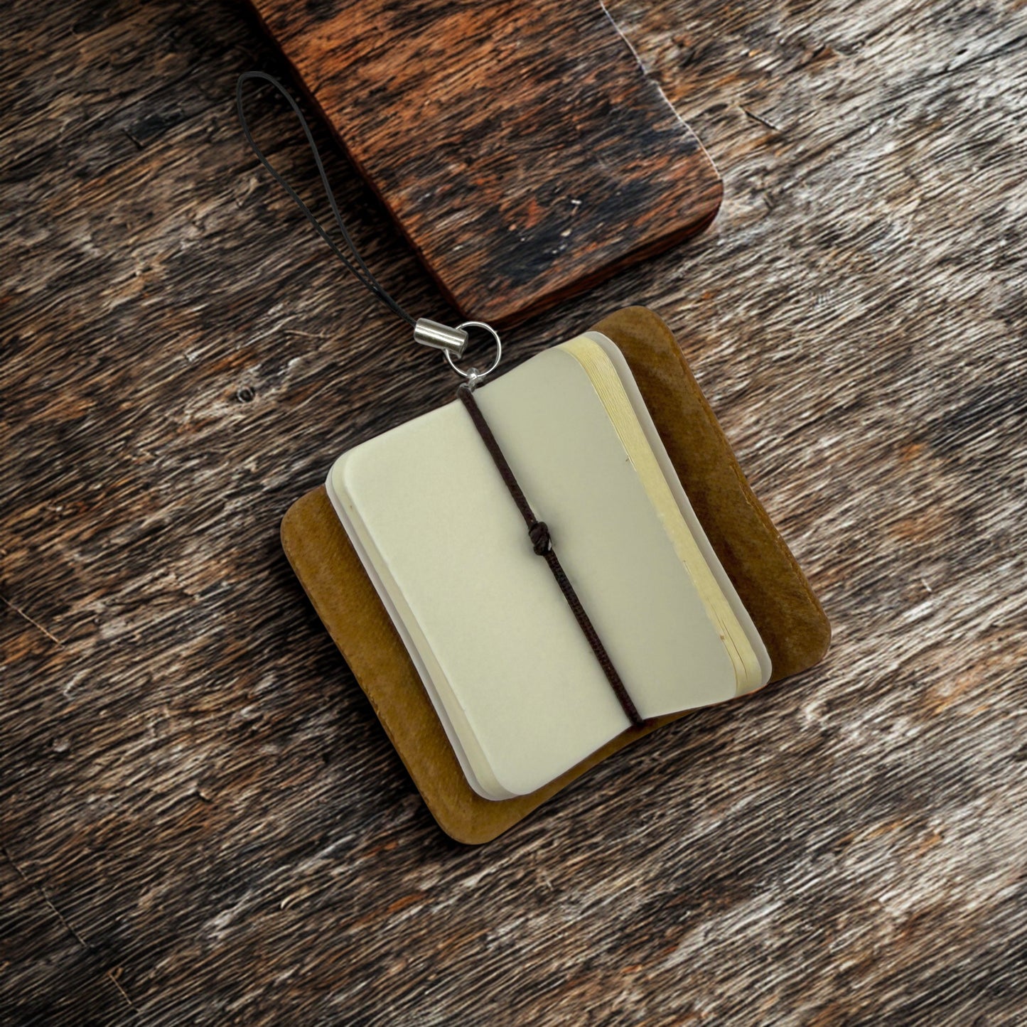 Small open book with a brown cover on a wooden surface