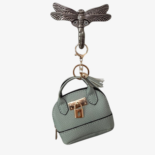 Keychain with a miniature handbag and dragonfly design on a white background