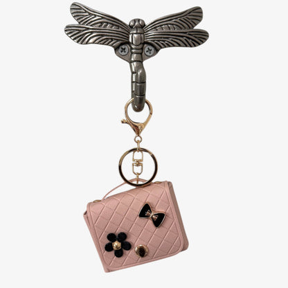 Keychain with dragonfly design and pink quilted bag charm on a white background