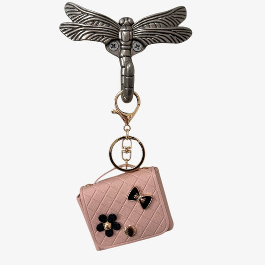 Keychain with dragonfly design and pink quilted bag charm on a white background