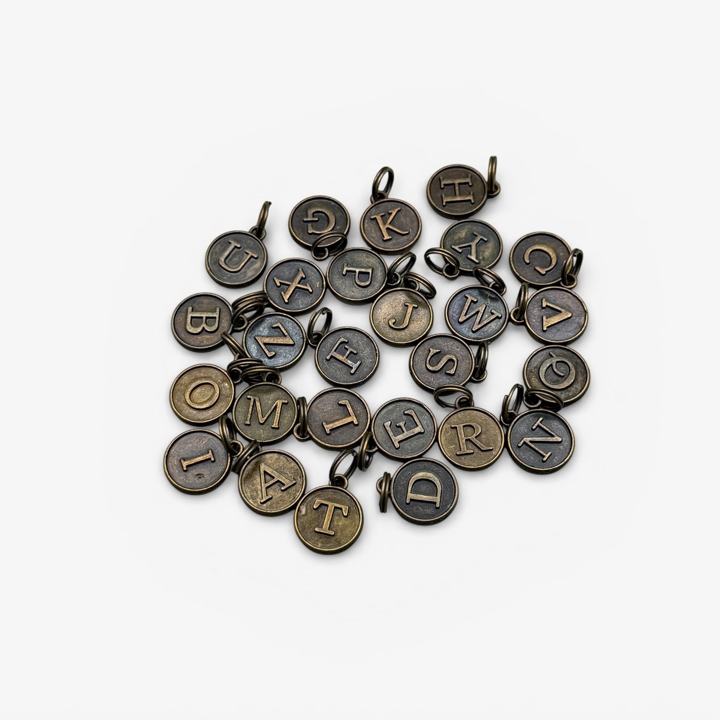 Collection of bronze letter charms on a white background