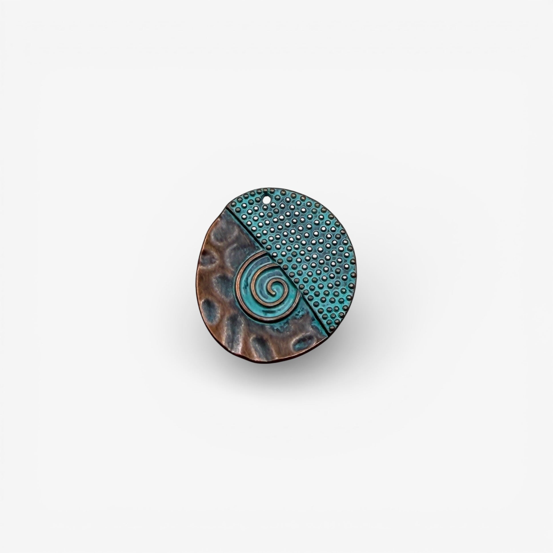 Round antique copper and turquoise pendant with a spiral design on a white background