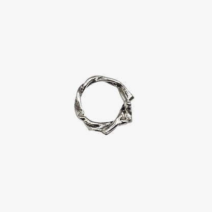 Silver ring with a twisted design on a white background