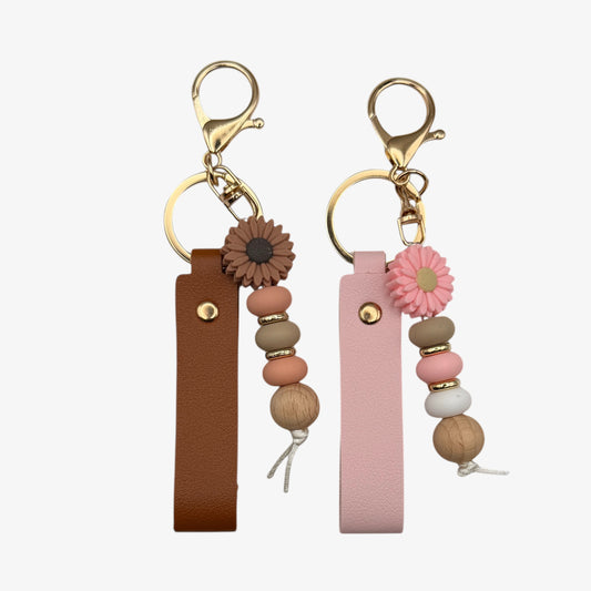 Two keychains with floral and bead designs on a white background